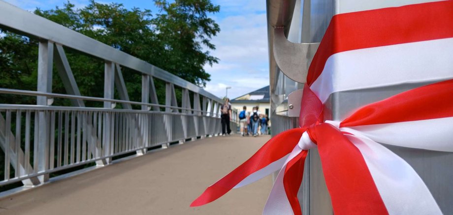 Schwarze Brücke_4 Durchgeschnittenes Band nach Eröffnung einer Brücke; im Hintergrund Schüler, die die Brücke überqueren