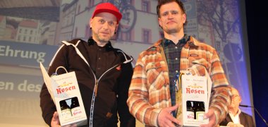Jahresempfang_Besondere Ehrung Zwei Männer mit Präsenten auf Bühne