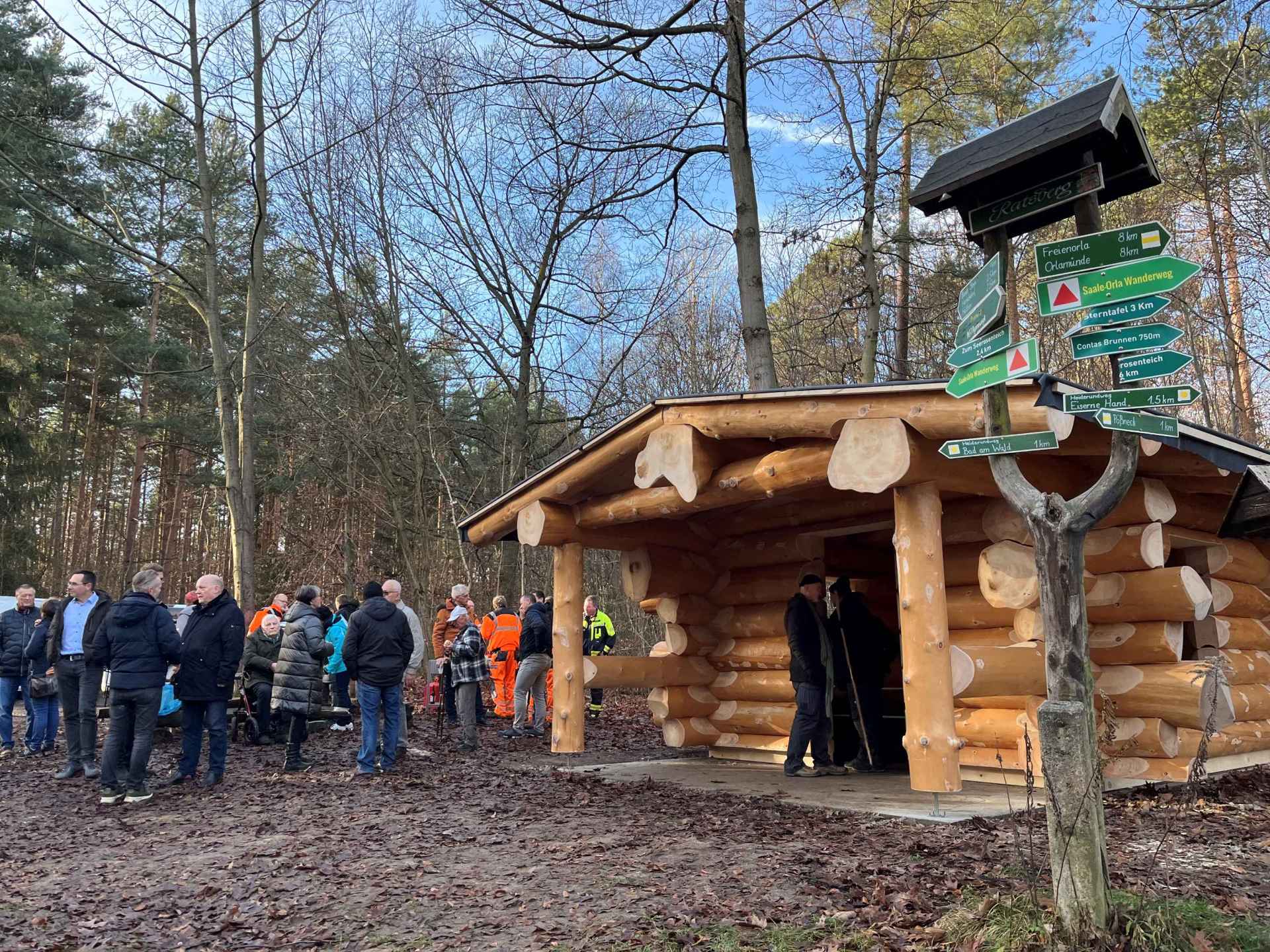Schutzhütte in Blockbauweise mit Menschen davor