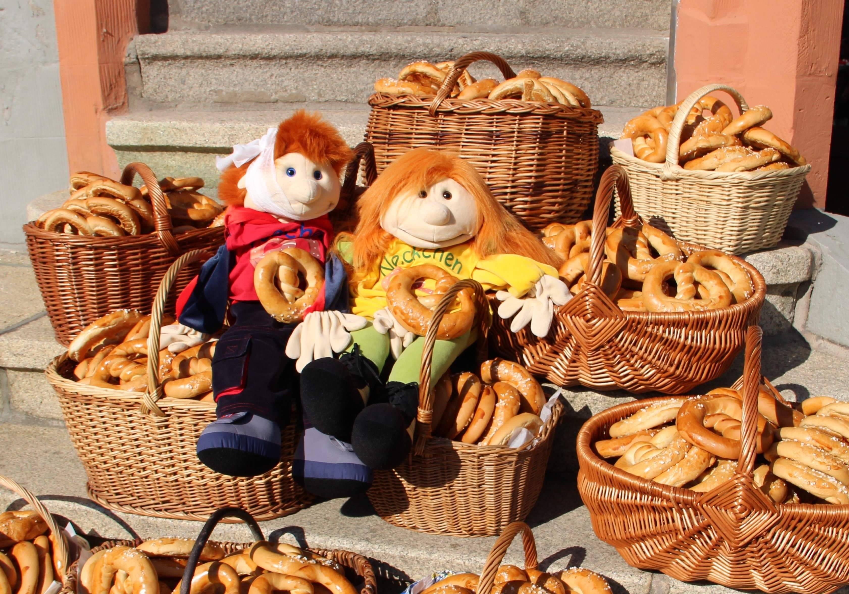 2 Handpuppen mit Brezelkörben auf Rathaustreppe