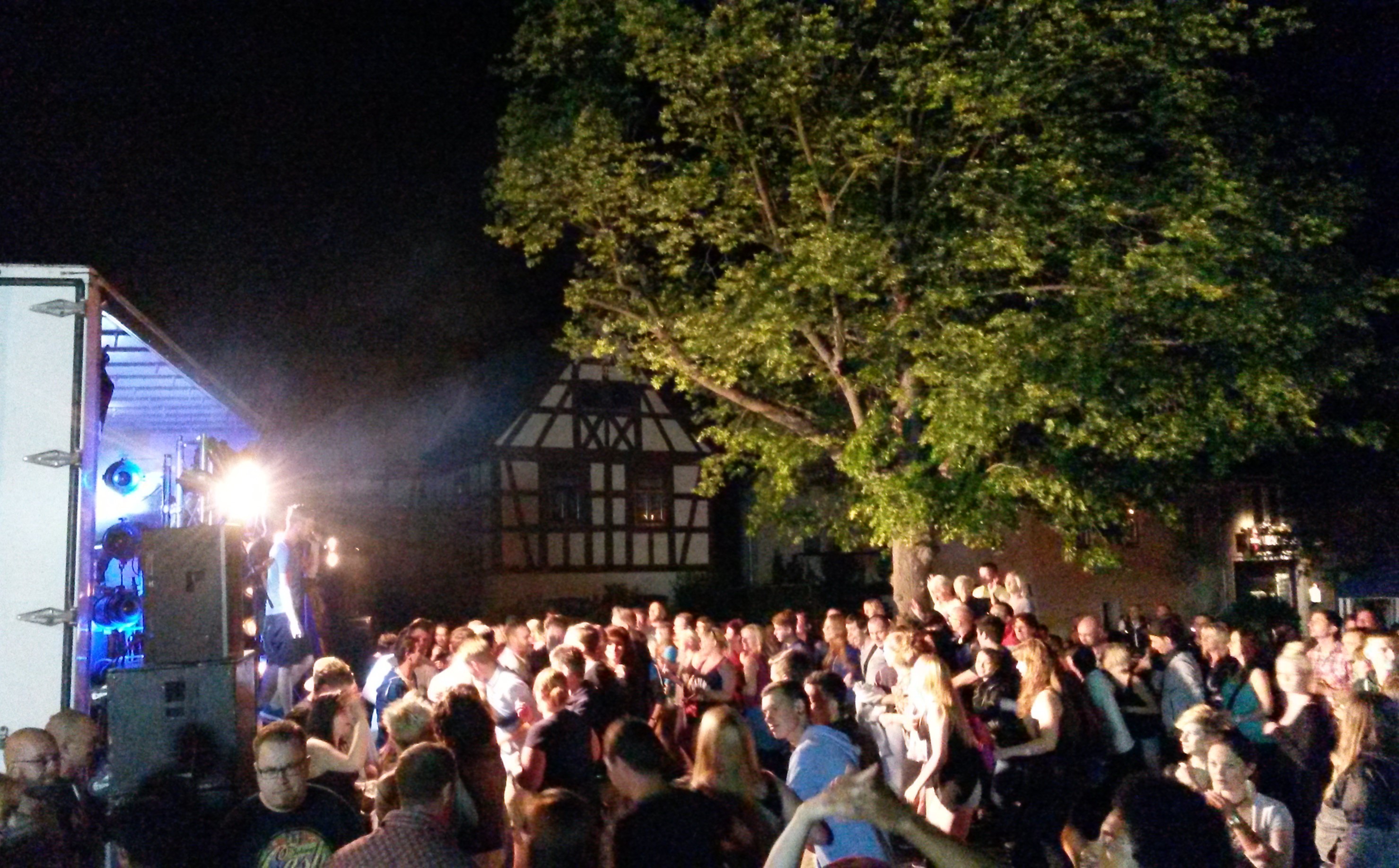 Brunnenfest Jüdewein Menschen feiern im Dunkeln vor einer Bühne