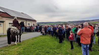 Menschentraube neben einem Mann als Goethe verkleidet auf einem Pferd