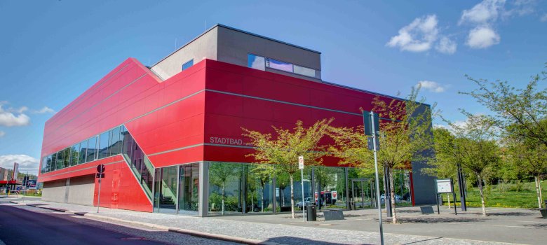 Außenansicht Stadtbad mit markanter moderner roter Fassade