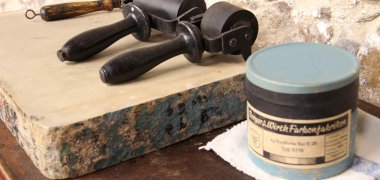 Historische Schaudruckerei Detail Farbdose und Handroller in der Historischen Schaudruckerei