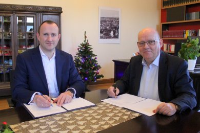 Vergleich Stadt Pößneck und Landkreis Landrat und Bürgermeister sitzen am Tisch und unterschreiben