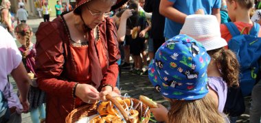 Brezeltagsstifterin Charlotte von Wolfersdorf gibt Brezeln an Kinder aus