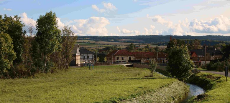 Häuser umgeben von Wiese und Feldern