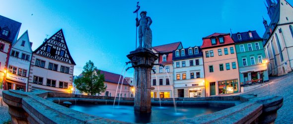 Nahaufnahme Marktbrunnen in der Dämmerung mit steinernem Marktbornmännchen in der Mitte